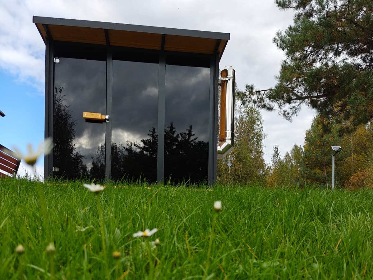 Gartensauna aus der Froschperspektive mit Wiese im Vordergrund